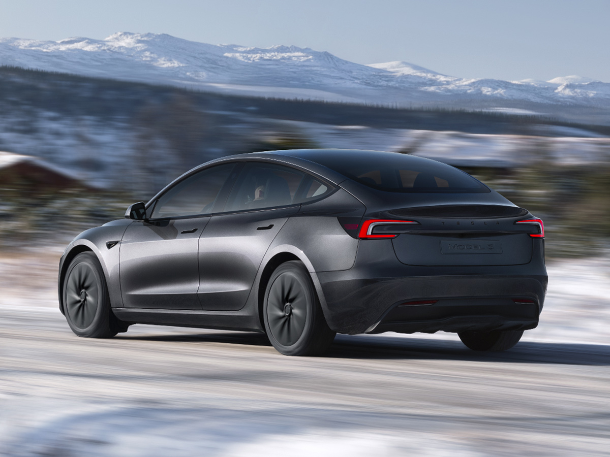 Vista trasera del Tesla Model 3 negro circulando por una carretera