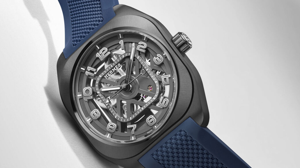 Hermès H08 Squelette 2026 con esfera esqueletizada gris, cifras arábigas en relieve y correa de caucho azul