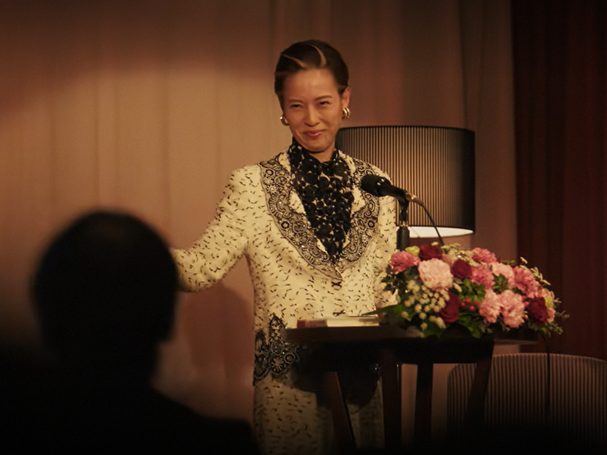 Kazuko Hosoki dando una conferencia ante su público en la miniserie Te irás al infierno de Netflix
