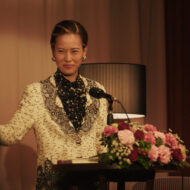 Netflix estrena hoy la miniserie de 8 episodios sobre la adivina más temida de Japón: profecías brutales, millones en ventas y rumores de mafia Erika Toda interpreta a Kazuko Hosoki dando una conferencia en la miniserie de Netflix Te irás al infierno