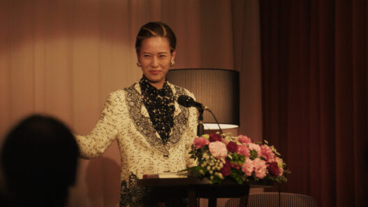 Erika Toda interpreta a Kazuko Hosoki dando una conferencia en la miniserie de Netflix Te irás al infierno