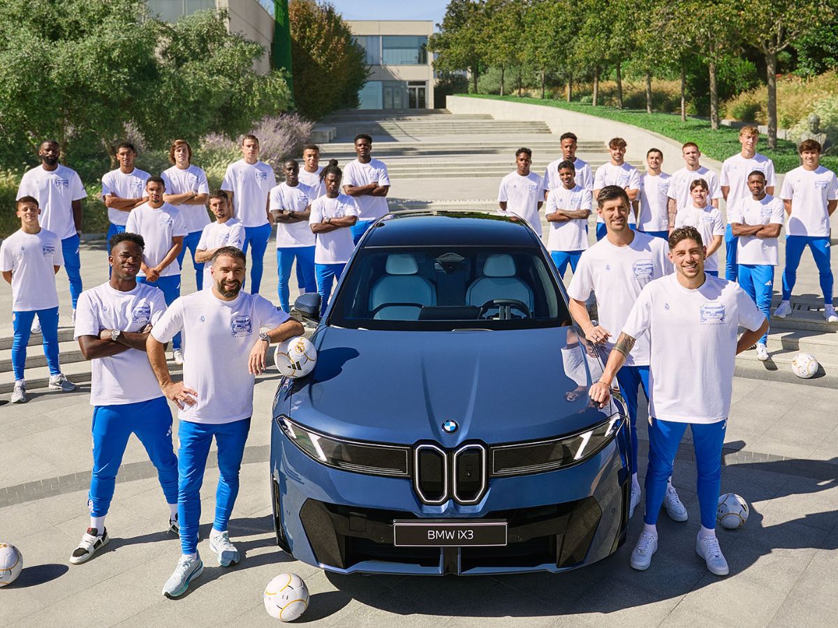 Jugadores Real Madrid posando con el BMW iX3
