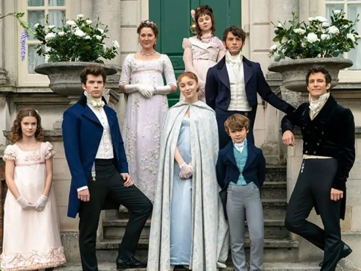 Reparto principal de la quinta temporada de Los Bridgerton posando frente a la mansión familiar con vestuario de época Regency.