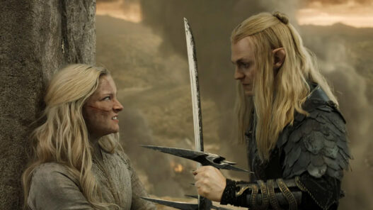 Sauron amenaza con una espada a Galadriel apoyada contra un muro de piedra en una escena de 'Los anillos del poder'.
