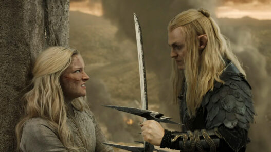 Sauron amenaza con una espada a Galadriel apoyada contra un muro de piedra en una escena de 'Los anillos del poder'.