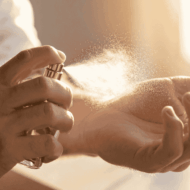 Las mejores brumas corporales para hombre este verano hombre echándose fragancia en la muñeca