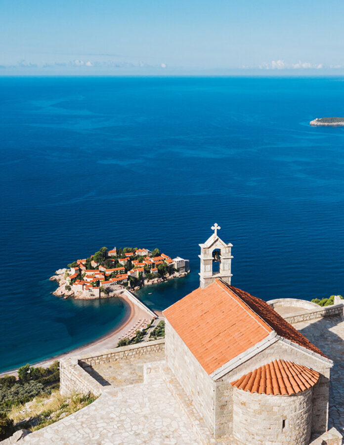 Vista aérea de la isla de Sveti Stefan en Montenegro con sus tejados rojos y el mar Adriático