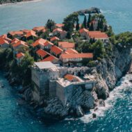 El pueblo medieval convertido en hotel de lujo que se esconde en una isla privada del Adriático y que pocos españoles conocen Vista aérea del pueblo amurallado de Sveti Stefan con casas de piedra y tejados de teja roja sobre el Adriático