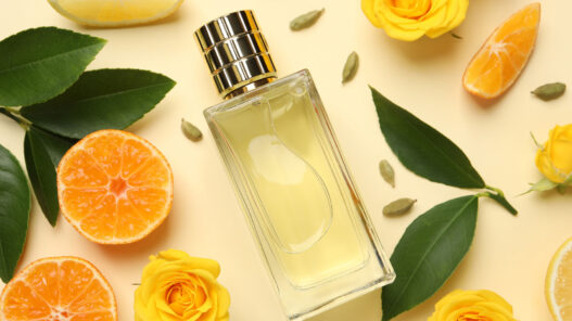 Perfumes cítricos hombre 2026 frasco de perfume entre ojas y frutas de naranja