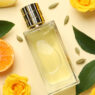 Perfumes cítricos hombre 2026 frasco de perfume entre ojas y frutas de naranja