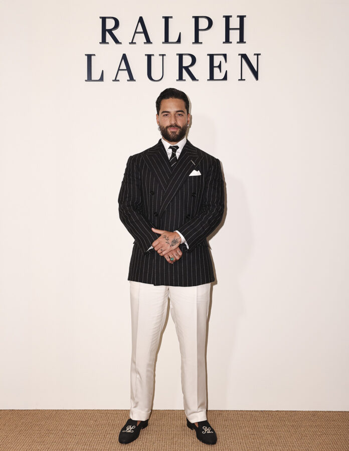 Maluma posa de cuerpo entero ante el logo de Ralph Lauren en Milán con traje de raya diplomática