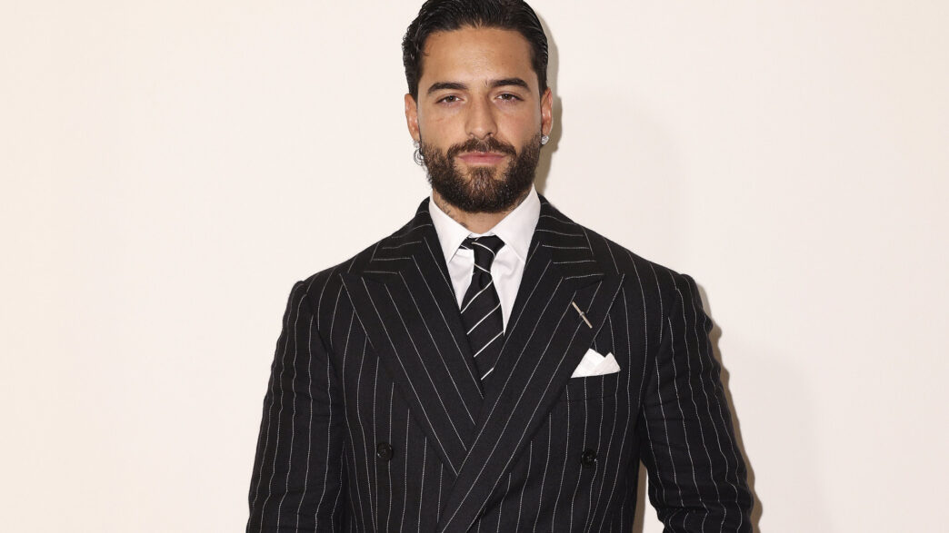 Retrato de Maluma con traje de raya diplomática y corbata negra en el desfile de Ralph Lauren