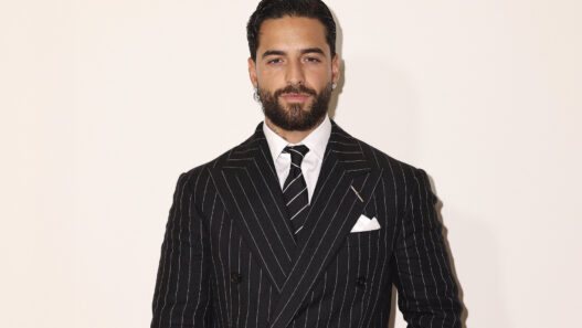 Retrato de Maluma con traje de raya diplomática y corbata negra en el desfile de Ralph Lauren