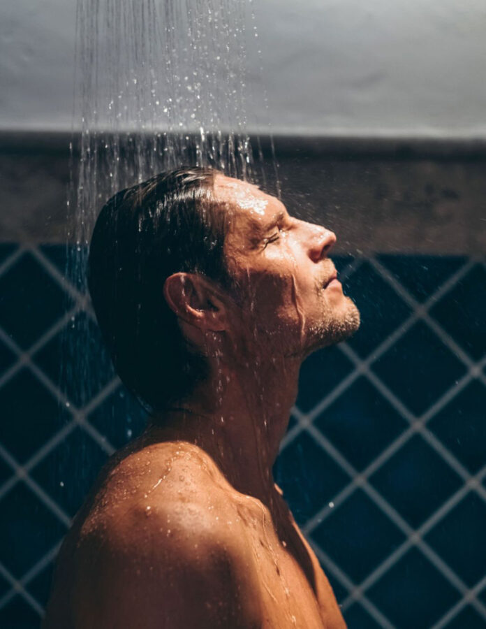 hombre bajo la ducha cara agua