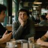hombre en cafetería aburrido con amigos
