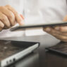 manos de un hombre trabajando con la tablet el ordenador y el móvil a la vez