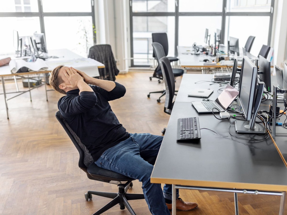 Hombre enfadado o agotado en su puesto de trabajo síndrome de burnout