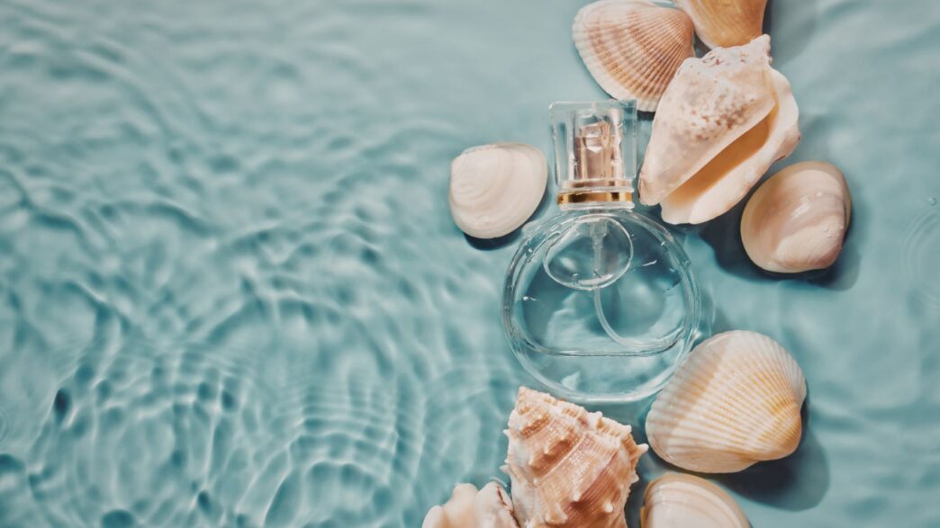 fraco de perfume sumergido en agua de mar con cochas al rededor.