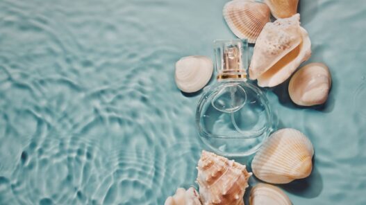 fraco de perfume sumergido en agua de mar con cochas al rededor.