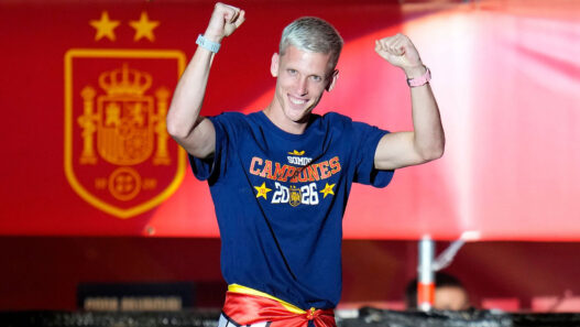 Dani Olmo celebra con los puños en alto la victoria de España en el Mundial 2026, con un reloj de correa rosa en la muñeca izquierda y otro de correa azul en la derecha.