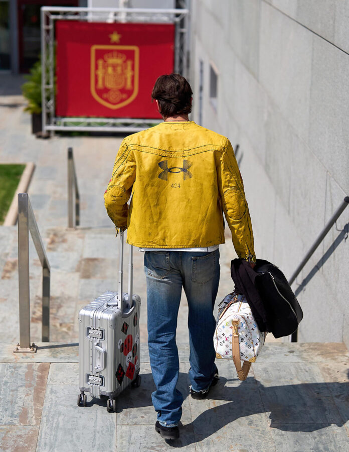 Ferran Torres de espaldas con maleta y bolso Louis Vuitton