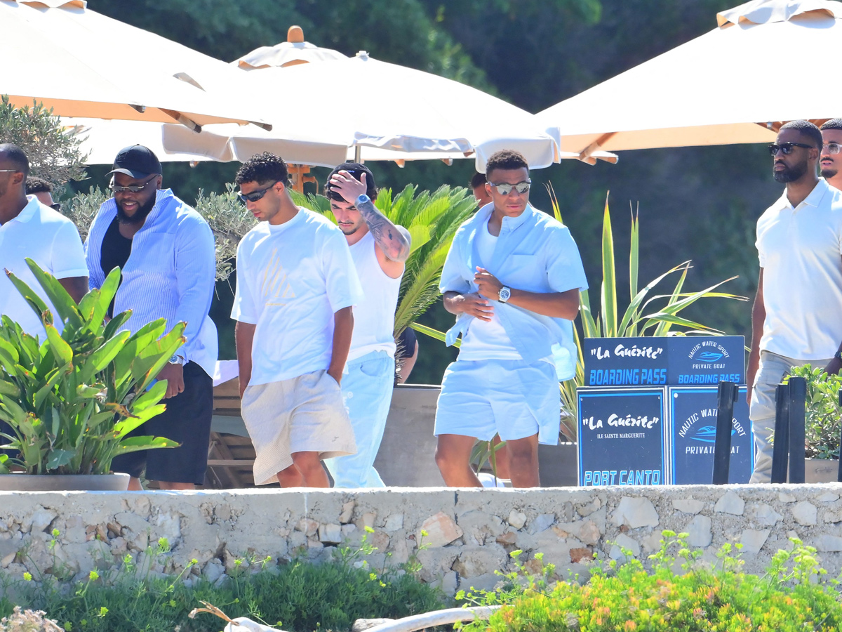 Kylian Mbappé y Achraf Hakimi cruzan la terraza del restaurante La Guérite bajo las sombrillas junto a su grupo de amigos