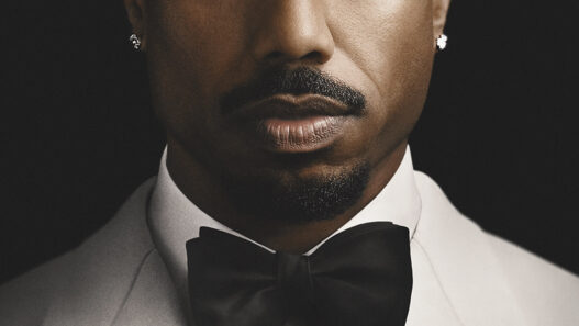 Michael B. Jordan con esmoquin blanco y pajarita negra en la imagen promocional de El Secreto de Thomas Crown
