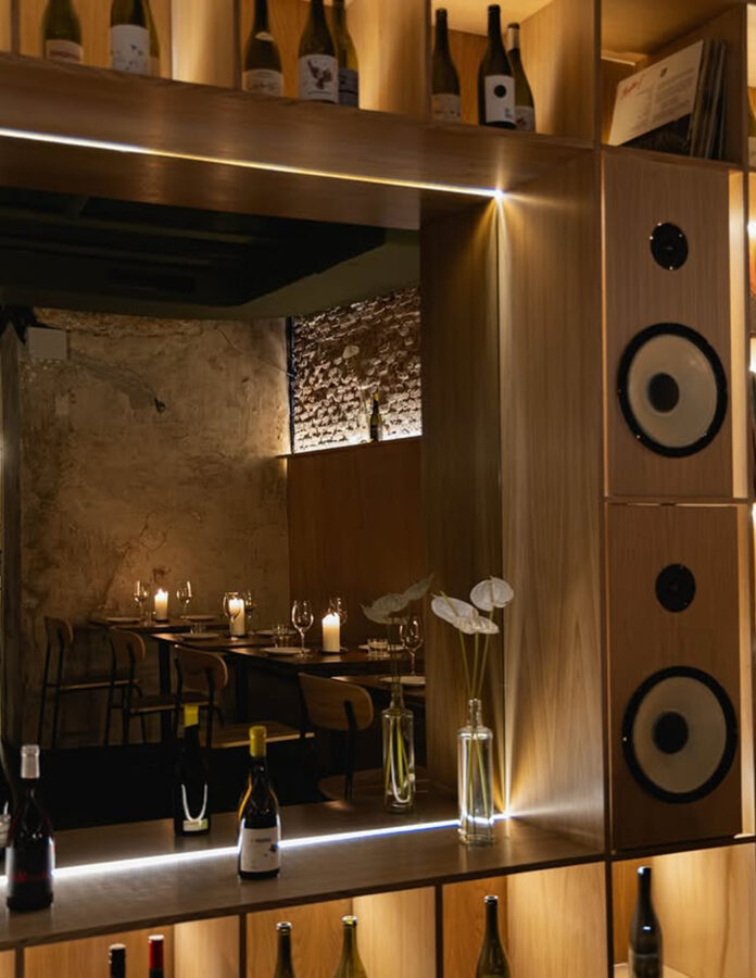 Botellas de vino, altavoces hi-fi y mesas con velas en Gastón Wine Bar, barrio de Salamanca