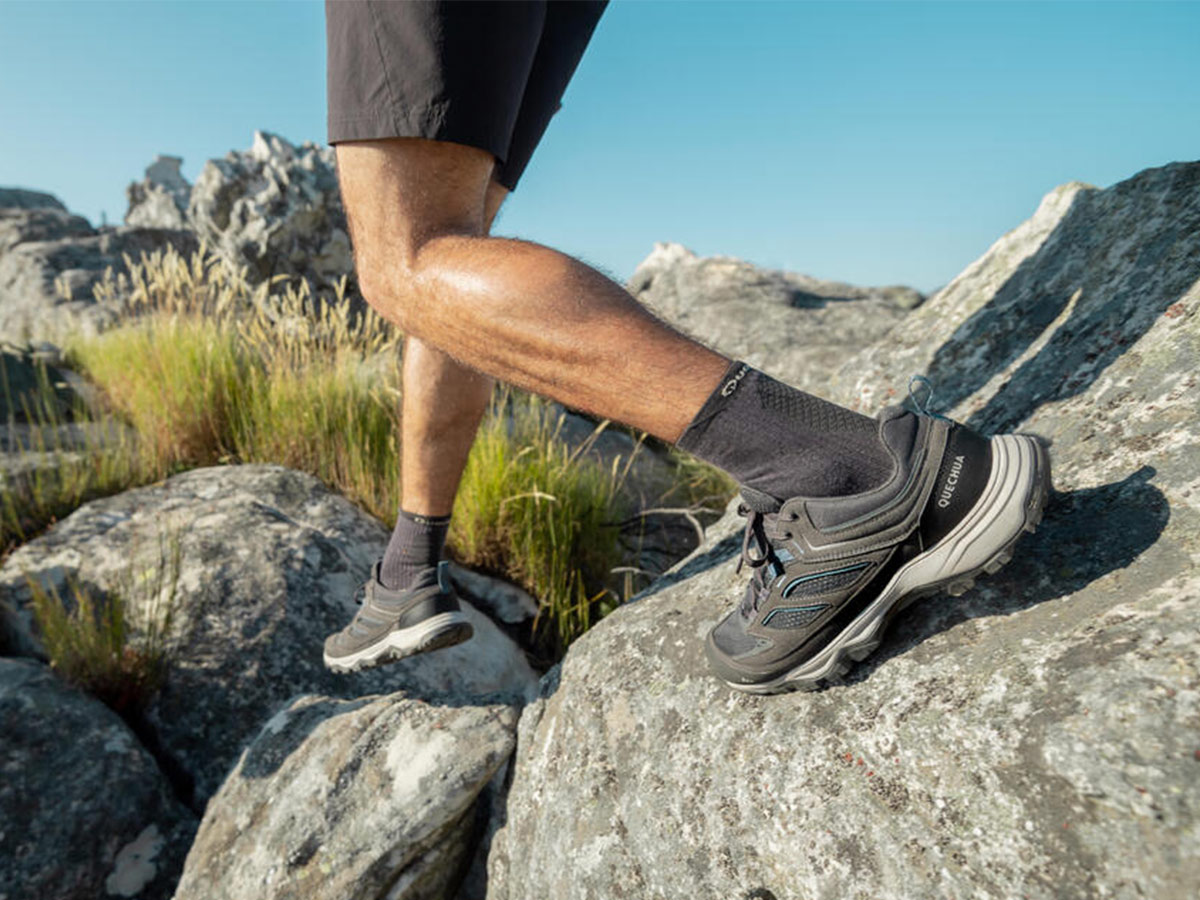 Zapatillas de montaña Quechua MH100 gris de Decathlon pisando sobre roca durante una ruta de trekking