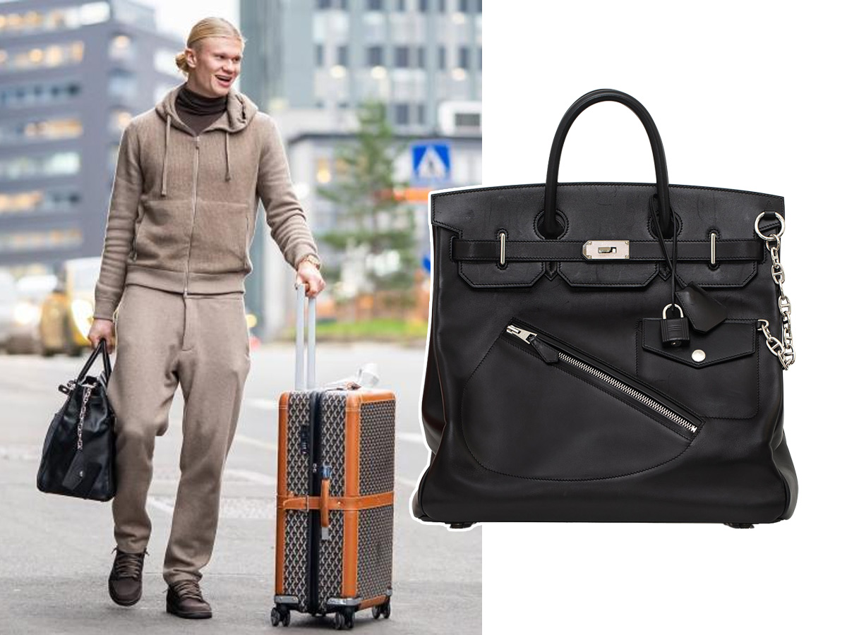 Erling Haaland en el aeropuerto con chándal beige, maleta Goyard y su bolso Hermès HAC Rock negro con cremallera diagonal y cadena Chaîne d'Ancre