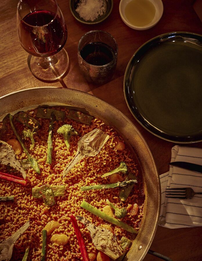 Paella de verduras del restaurante Arroz y Fuego de Lanzarote junto a una copa de vino tinto de La Geria