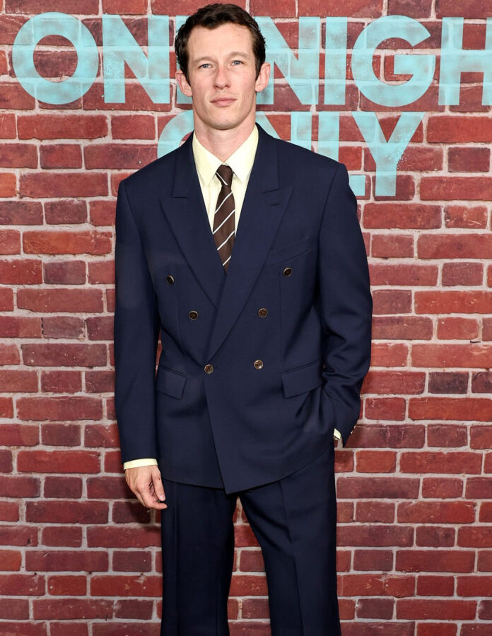 Callum Turner posa con traje de Louis Vuitton azul marino de botones dorados en la alfombra roja del estreno de One Night Only