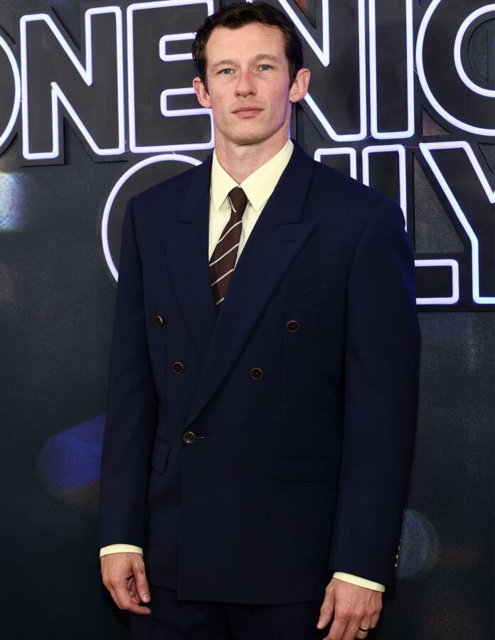 Callum Turner con traje cruzado azul marino de Louis Vuitton, camisa amarillo pálido y corbata de rayas marrones en el estreno de One Night Only en Nueva York