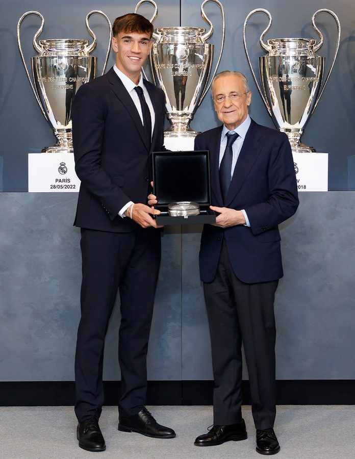 Carlos Espí posa con Florentino Pérez y la insignia del Real Madrid frente a las copas de Europa del club