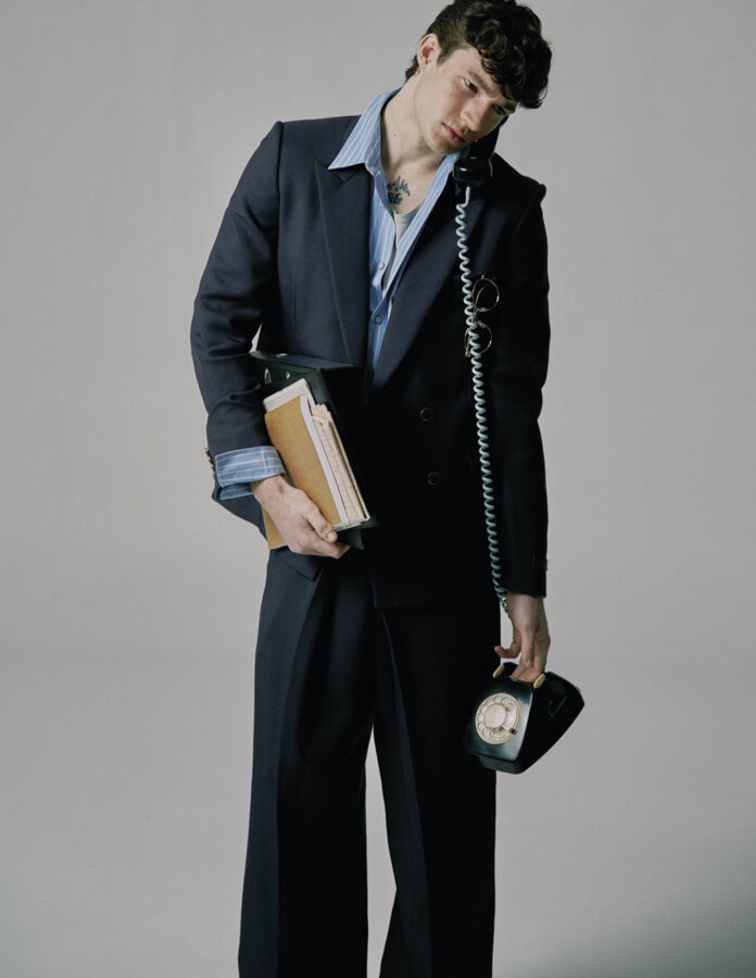 David Laporte posa con traje Louis Vuitton y un teléfono antiguo en Rísbel Magazine