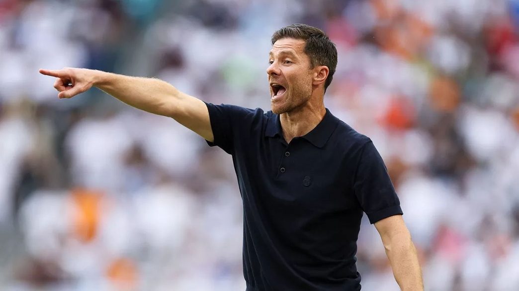 Xabi Alonso con polo negro señalando durante un partido de fútbol