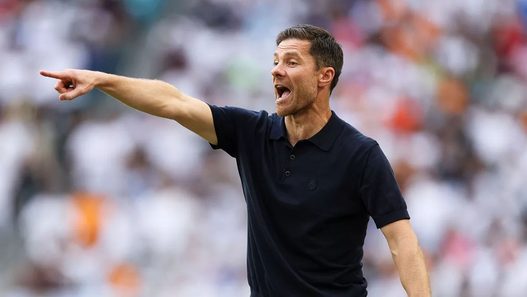 Xabi Alonso con polo negro señalando durante un partido de fútbol