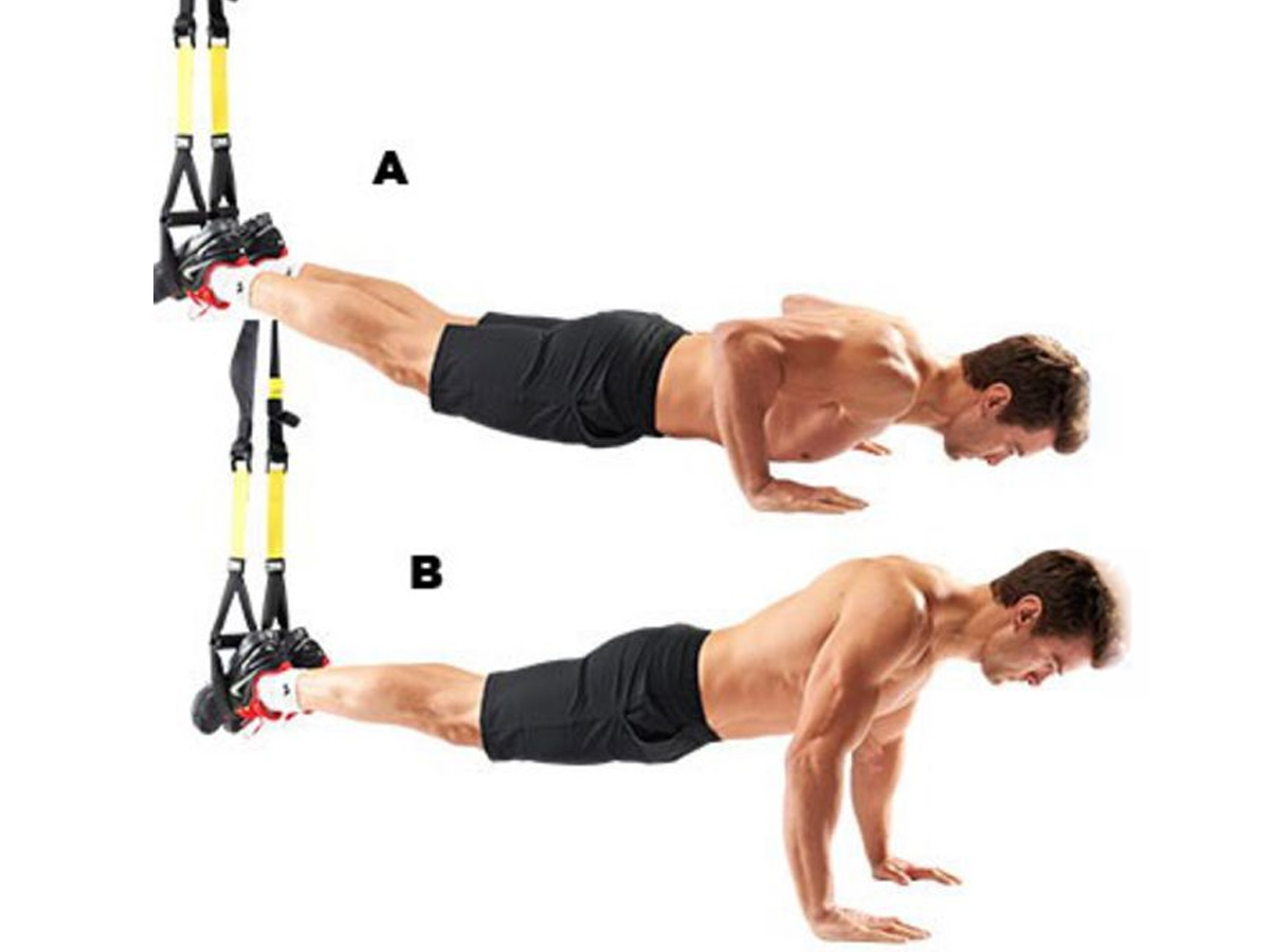 Hombre haciendo flexiones en TRX con los pies en suspensión para progresar en fuerza del tren superior