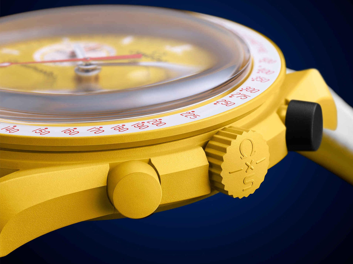 Detalle lateral del Swatch MISSION TO THE SUN - SOLAR ECLIPSE con el pulsador negro de Bioceramic junto a la corona amarilla
