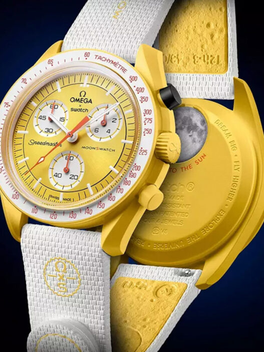 Reloj amarillo Swatch MISSION TO THE SUN - SOLAR ECLIPSE exhibido por delante y por detrás sobre fondo oscuro