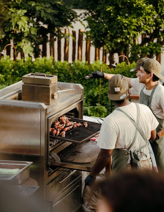 Cocineros del restaurante Madunia Ibiza preparando brochetas en el horno de brasas al aire libre
