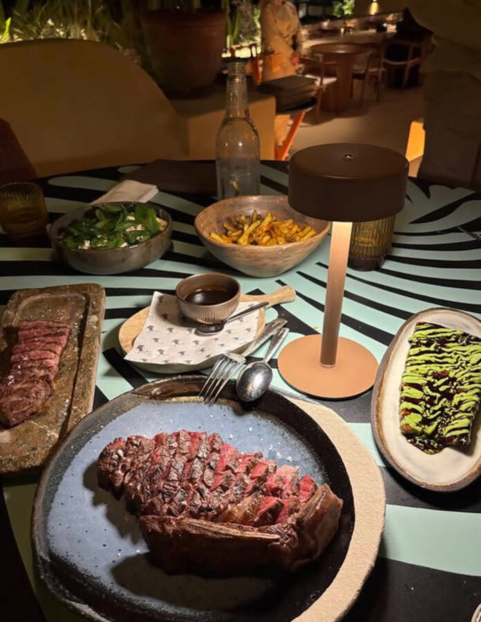 Mesa del restaurante Madunia en Ibiza con solomillo de ternera fileteado, patatas fritas y demi-glace