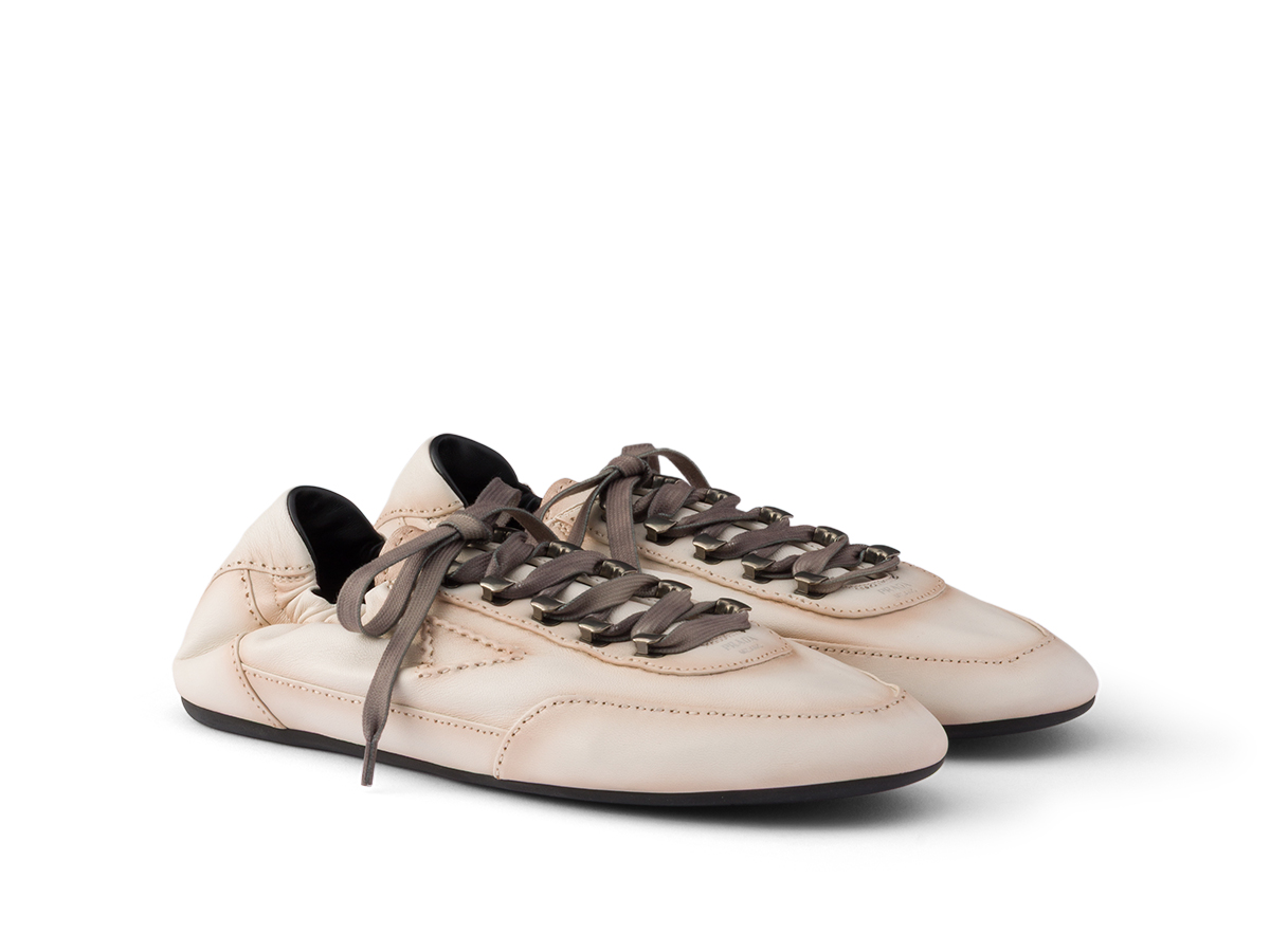 Sneakerinas de Prada en piel color crema con cordones grises y herrajes metálicos, otoño 2026