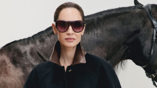 Eugenia Silva con gafas de sol Mó DOMA burdeos de lente degradada junto a un caballo negro