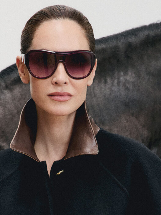 Eugenia Silva con gafas de sol Mó DOMA burdeos de lente degradada junto a un caballo negro