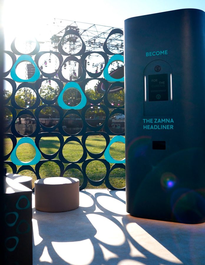 Fotomatón «Become the Zamna Headliner» de la House of IQOS con la celosía de círculos y el escenario de Zamna Madrid al fondo