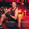 Joey Till Barrys en gimnasio haciendo biceps