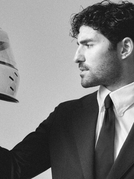 José Condessa vestido con traje de chaqueta y casco de moto en sesión de fotos para Rísbel Magazine