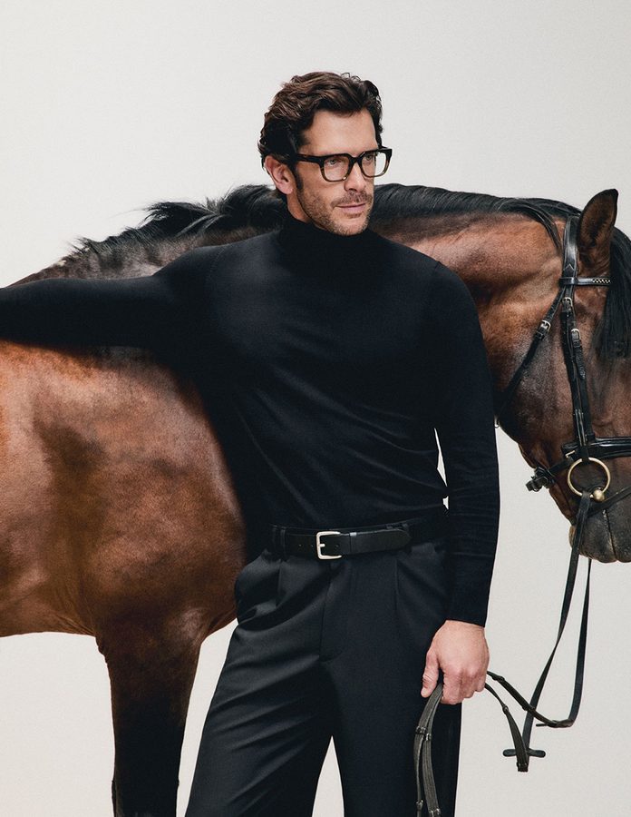 Hombre con gafas graduadas Mó DOMA en carey oscuro junto a un caballo con brida