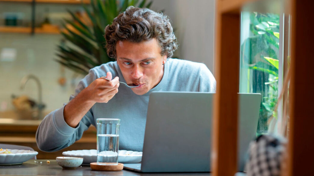 hombre comiendo en el trabajo delante del ordenador